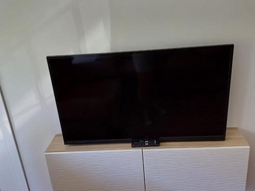 a flat screen tv sitting on top of a cabinet at Lyrioshomes Apartamento Filpo Rojas , Sevilla in Seville