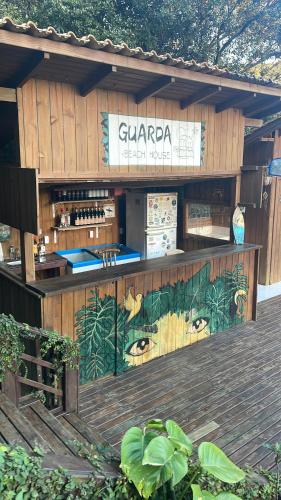 a building with a bar with a sign on it at Pousada Guarda Beach House in Guarda do Embaú