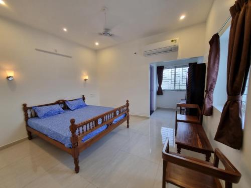 1 dormitorio con 1 cama y 1 silla en RVS Chalet, en Pondicherry
