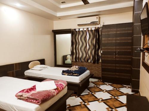 a room with two beds and a mirror at Hotel Bhagwani Palace in Jorhāt