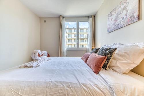 un grand lit blanc dans une chambre avec une fenêtre dans l'établissement Ambiance cosy: 4 personnes-wifi fibre-tout équipé, à Grenoble