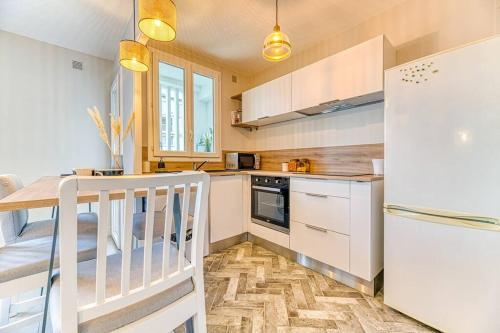 une cuisine avec un réfrigérateur blanc et une table dans l'établissement Ambiance cosy: 4 personnes-wifi fibre-tout équipé, à Grenoble