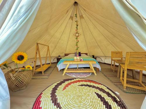 una habitación con una tienda de campaña con una mesa y una alfombra en El Cocotal Tintipán By Ashram, en Tintipan Island