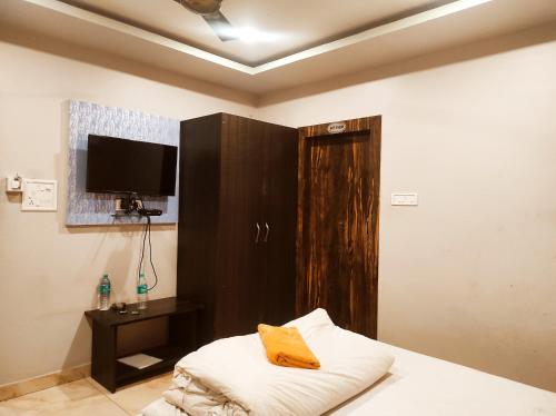 a room with a bed with a tv and a cabinet at Hotel Bhagwani Palace in Jorhāt