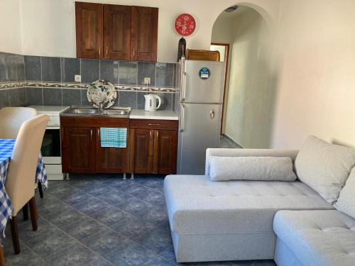 eine Küche mit einem Sofa und einem weißen Kühlschrank in der Unterkunft Bay Mola Aparts in Kotor