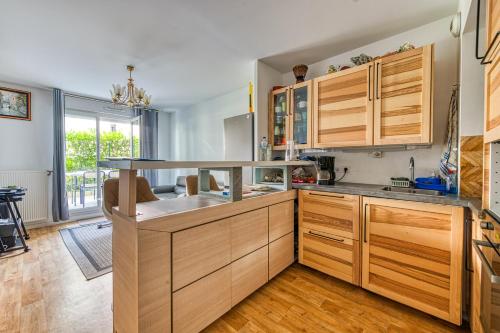 uma cozinha com armários de madeira e um lavatório em Le Mendès France - Région parisienne em Vauréal