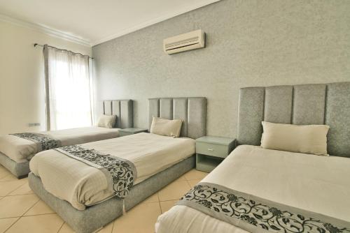 ein Hotelzimmer mit 2 Betten und einem Fenster in der Unterkunft Appart Hôtel Founty Beach in Agadir