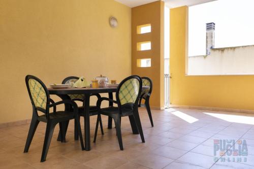 - une salle à manger avec une table et des chaises dans l'établissement Appartamento Fontana Greca 4 ,Gallipoli, à Gallipoli