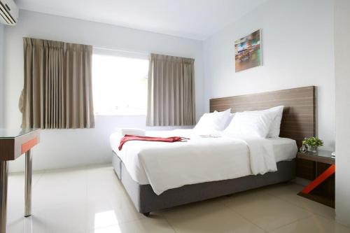 a bedroom with a large white bed with a window at Praso Residence in Bangkok