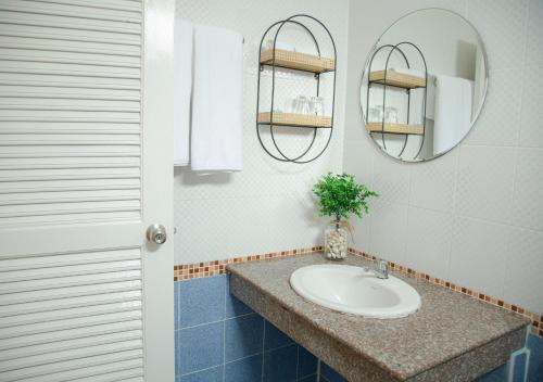 uma casa de banho com um lavatório e um espelho em RoomQuest Phuket Patong Beach em Praia de Patong