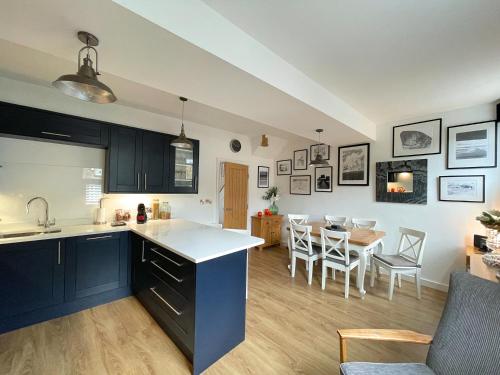 Lovely Comfortable 3BR Property في Nether Edge: مطبخ وغرفة معيشة مع طاولة وكراسي