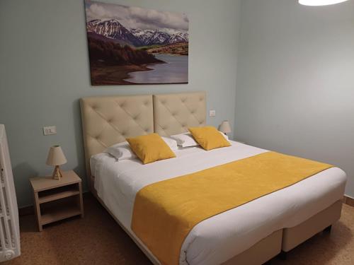 a bedroom with a large bed with yellow pillows at Relais del borgo in Guardiagrele
