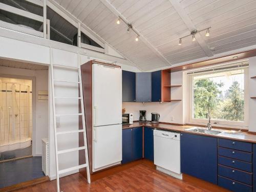 a kitchen with blue cabinets and a white refrigerator at 11 person holiday home in Str by in Strøby