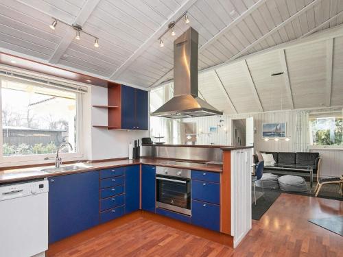 a kitchen with blue cabinets and a stove top oven at 11 person holiday home in Str by in Strøby