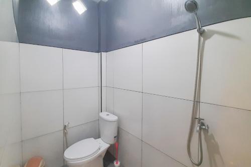 ein Bad mit einem WC und einer Dusche in der Unterkunft Delvia Bromo Homestay Mitra RedDoorz in Pasuruan