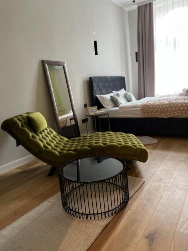 a living room with a bed and a green ottoman at ROOM 44 in Osijek