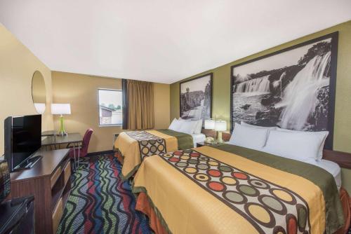 a hotel room with two beds and a flat screen tv at Super 8 by Wyndham Farmington in Farmington