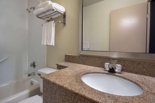 a bathroom with a sink and a toilet and a mirror at Days Inn by Wyndham Encinitas Moonlight Beach in Encinitas