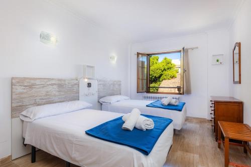 a bedroom with two beds and a window at Sa Coromina in Cala Ratjada