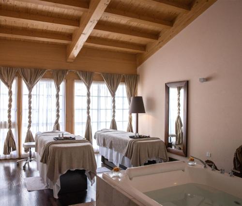 a bathroom with two beds and a bath tub at Mont Cervin Palace in Zermatt