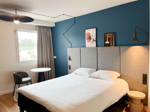 um quarto com uma cama grande e uma parede azul em ibis Martigues Centre em Martigues