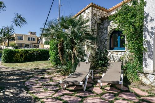 a pair of chairs sitting in front of a house at Art- Apartamentos Revilla Tacke H in Empuriabrava