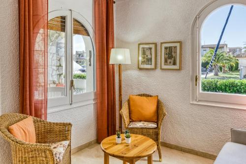 a room with two chairs and a table and two windows at Art- Apartamentos Revilla Tacke H in Empuriabrava