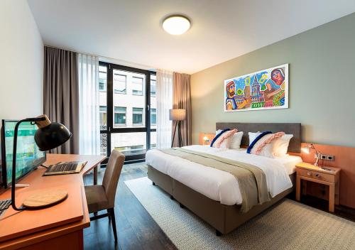 a hotel room with a bed and a desk with a computer at KONCEPT HOTEL Benedikt in Siegburg