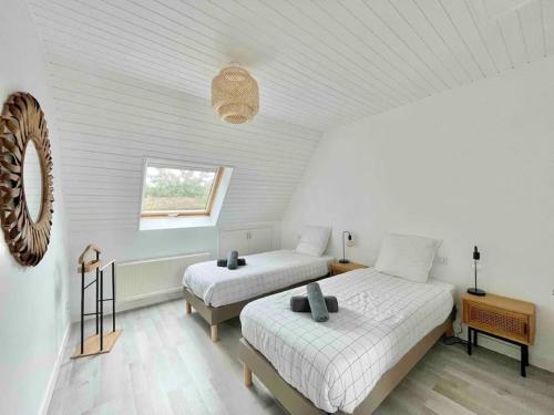 1 dormitorio con 2 camas y ventana en La villa des Dunes - 80m de la plage/paddle/vélos, en Fouesnant