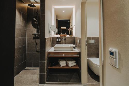 ein Bad mit einem Waschbecken und einem WC in der Unterkunft HIIVE Oldenburg in Oldenburg