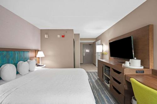um quarto de hotel com uma cama grande e uma televisão de ecrã plano em Hampton Inn Cleveland-Westlake em Westlake