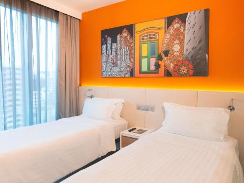 2 camas en una habitación con pared de color naranja en Mercure Singapore Bugis en Singapur
