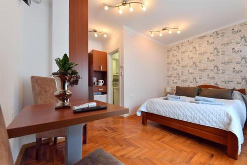 a bedroom with a bed and a table and a desk at Prenoćište Dvorište in Novi Sad