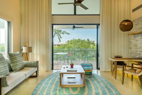 a living room with a couch and a table at Andaz Mayakoba - a concept by Hyatt in Playa del Carmen