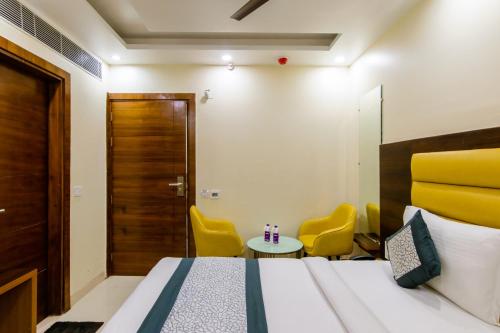 a bedroom with a bed and two yellow chairs at Hotel Royal Rosette with free Wi-Fi Near New Delhi Railway Station in New Delhi