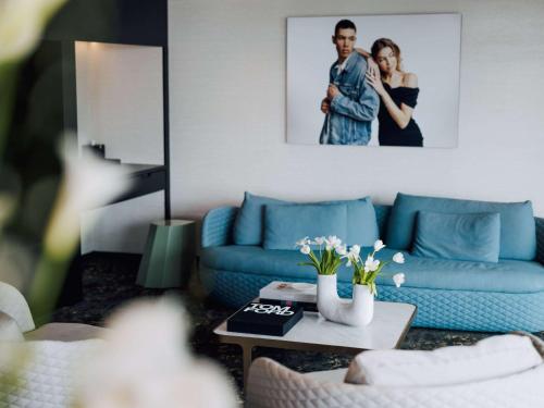 un soggiorno con divano blu e tavolo di SO/ Auckland ad Auckland