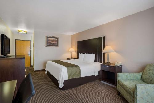 a hotel room with a bed and a chair at Quality Inn Richfield I-70 in Richfield