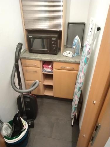 a small kitchen with a microwave and a table at Ferienwohnung Romy Müller in Mohlsdorf