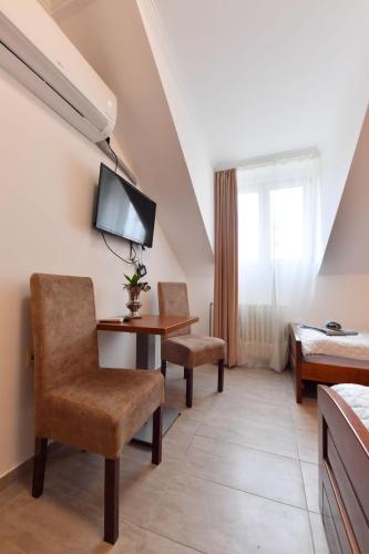 Habitación de hotel con escritorio y cama en Prenoćište Dvorište, en Novi Sad