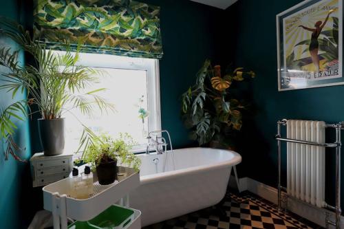 uma casa de banho com banheira e vasos de plantas em Stylish townhouse 15 mins to Laines & Seafront em Brighton & Hove