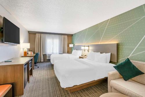 a hotel room with two beds and a couch at Comfort Inn & Suites Louisville Airport Fair & Expo in Louisville