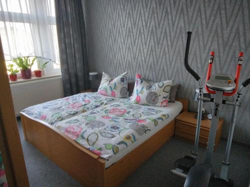 a bedroom with a bed and a treadmill at Ferienwohnung Romy Müller in Mohlsdorf