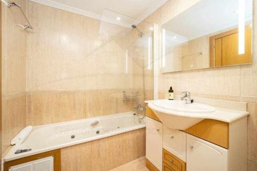 een badkamer met een wastafel en een bad bij San Miguel Playa in Gijón
