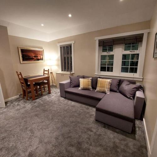 a living room with a couch and a table at Crossways Cottage Quirky 2 bedroom cottage in Damdale, Central Peebles in Peebles