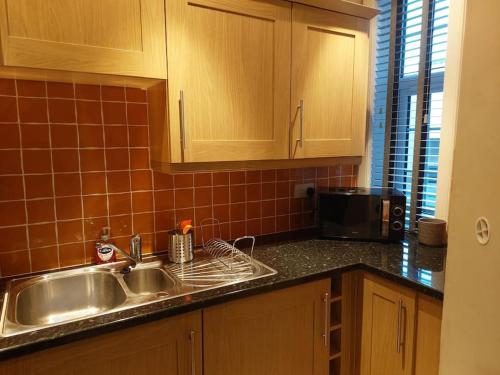 cocina con fregadero y microondas en Crossways Cottage Quirky 2 bedroom cottage in Central location, en Peebles