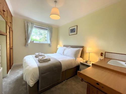 una camera da letto con un letto grande e un lavandino di Pass the Keys Traditional Scottish Cottage in Beautiful Location a Rockcliffe