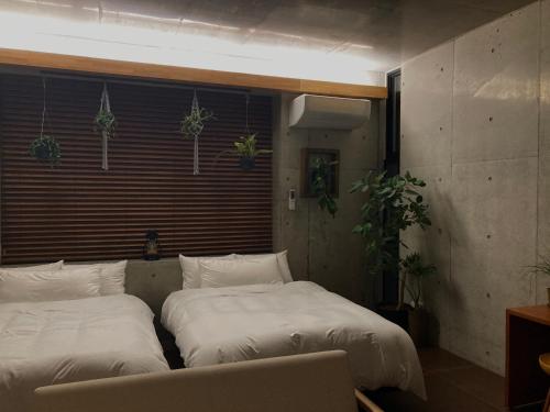 two beds sitting next to each other in a room at G.bouquet in Nakijin