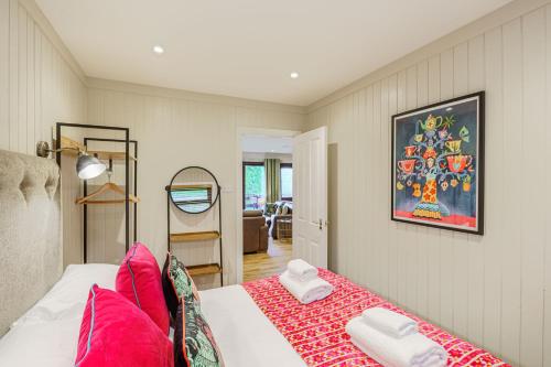 a bedroom with a bed with pink pillows at Conifer Lodge 25 with Hot Tub in Newton Stewart