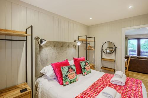 a bedroom with a bed with red pillows at Conifer Lodge 25 with Hot Tub in Newton Stewart