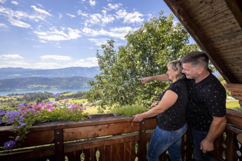a man and a woman standing on a wooden fence at Turnerhof in Millstatt